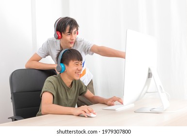 Two Multiethnic Teenage Boys Playing Computer Games At Home.