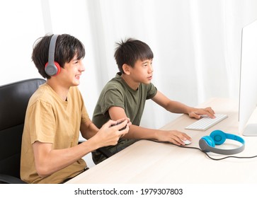 Two Multiethnic Teenage Boys Playing Computer Games At Home.