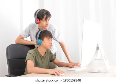 Two Multiethnic Teenage Boys Playing Computer Games At Home.