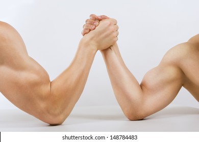 Two muscular hands clasped arm wrestling