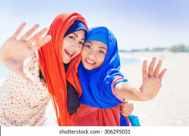 two muslim girls smiling at camera - Powered by Shutterstock