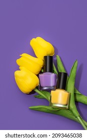 Two nail polish bottles: purple and yellow with yellow tulip flowers on purple background. Nail polish bottles with yellow tulips on purple background.