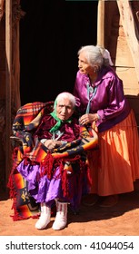 Two Navajo Women In Front Of Their Family Traditional Hogan Hut