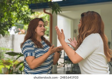 Two neighbors engaged in a heated argument outdoors. Neither one backing down due to pride, believing they are correct. - Powered by Shutterstock