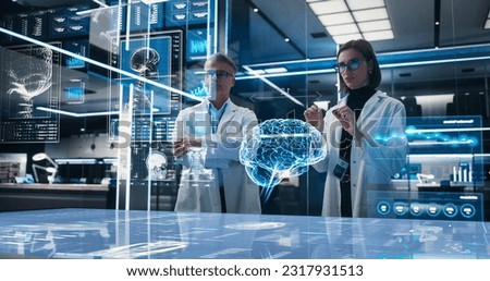 Two Neuroscientists Working With Computer-Powered VFX Hologram Of Human Brain And Nervous System In Futuristic Laboratory. Caucasian Man And Woman Working On Solutions for Brain Damage.