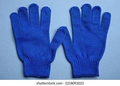 Two New Work Gloves Made Of Blue  Fabric Lie On A Gray Table