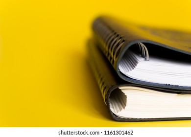 two notebook a side view of a side spring closeup yellow background