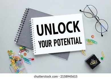 two notebooks on a gray background. text on notebook - Unlock your Potential - Shutterstock ID 2158945615