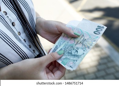 two notes of One hundred Czech crowns is holding a female hand. Currency concept