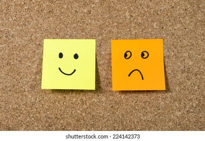 two notes stuck message cork board  and smiley   sad cartoon face expression in happiness versus depression   smile against adversity concept