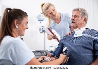 Two Nurses Care For An Intensely Awake Patient In The Hospital Nursing Home