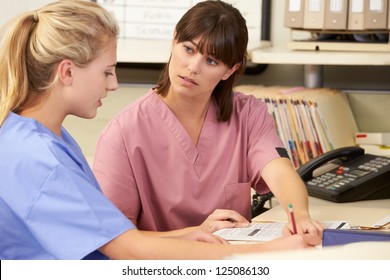 Two Nurses Working At Nurses Station