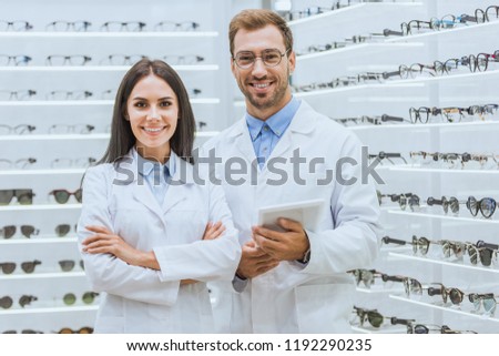two oculists with digital tablet looking at camera in optica