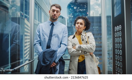 Two Office Colleagues Riding in Glass Elevator in a Modern Business Center on the Way From Work. Caucasian Male Specialist and Black Latin American Female Manager Casually Chat in the Lift. - Shutterstock ID 2136847625