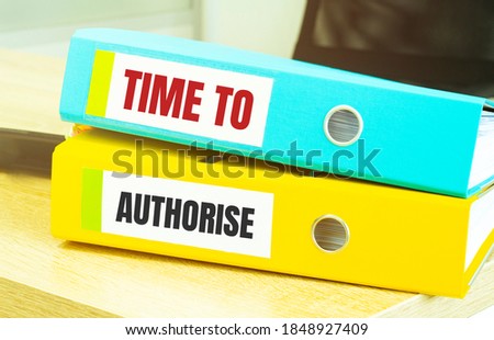 Two office folders with text TIME TO AUTHORISE