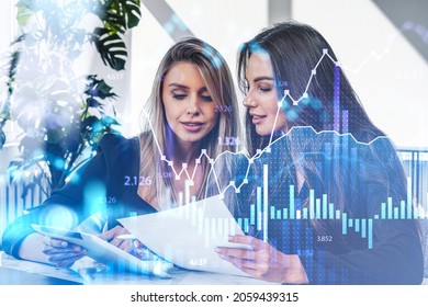 Two office women in black wear point at tablet, working in business room with plant. Double exposure with graphs dynamics and numbers. Concept of teamwork and financial analysis - Powered by Shutterstock