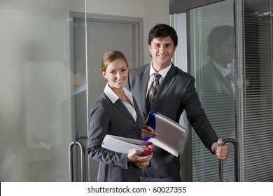 Two Office Workers In Suits Opening Boardroom Door