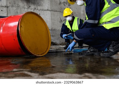 Two Officers of Environmental Engineering Wearing Protective Equipment with Masks Inspected Oil Spill Contamination in Warehouse Old, Hazardous Fuel Leakage and Environmental Concept.