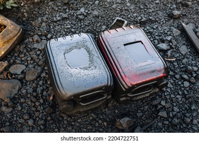 Two Old Dirty Canisters With Oil, Diesel, Gasoline, Oil, Smeared With Fuel Oil, Grease, Lie Against The Background Of Black Graphite, Coal In A Landfill. Photo, Top View.