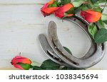 Two old horse shoes paired with silk red roses on a white-washed rustic wooden background makes a nice image with contrasting elements. Good for Kentucky Derby or any other equestrian theme.