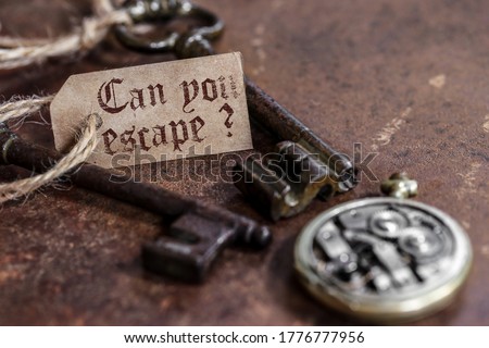 two old keys on a rusty metal table with labels : can you escape ?