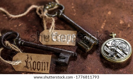 two old keys on a rusty metal table with labels : escape room