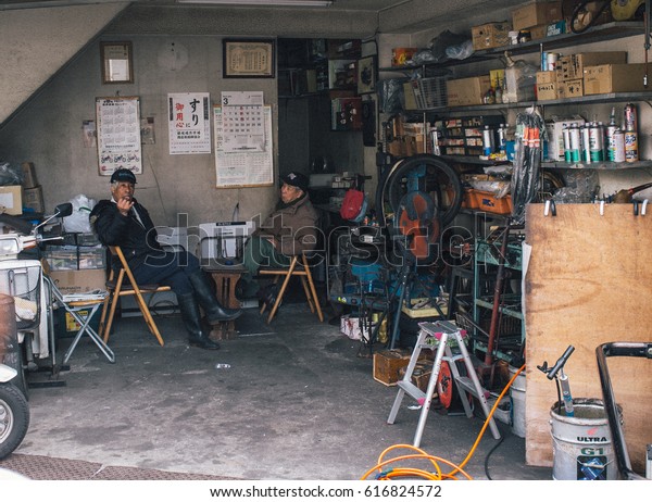 two old men worker rest after work at garage in\
tokyo japan,march 2016