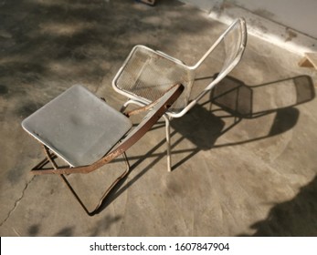 Two Old Metal Antique Chairs Left On The Lawn.