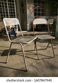 Two Old Metal Antique Chairs Left On The Lawn.