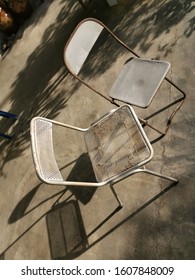 Two Old Metal Antique Chairs Left On The Lawn.