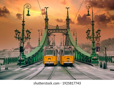 Two old yellows trams on the Liberty Bridge in Budapest. Architecture of Art Nouveau style.