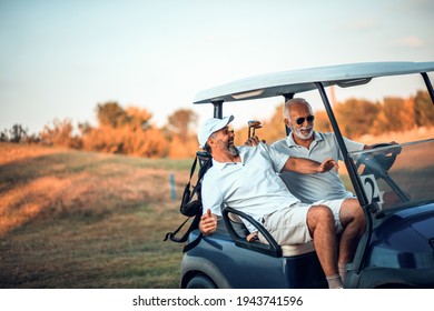 Two older friends are riding in a golf cart. - Powered by Shutterstock