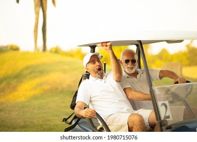 Two Older Friends Are Riding In A Golf Cart.