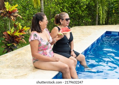 Two older women in bikini sitting by the pool and eating watermelon. - Powered by Shutterstock