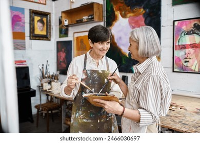 Two older women create art in a cozy studio. - Powered by Shutterstock