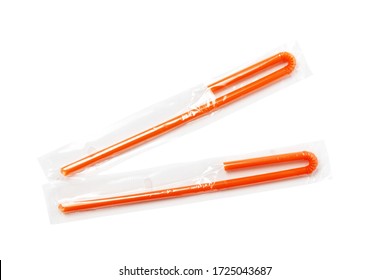 Two Orange Plastic Cocktail Straws In Transparent Packaging On A White Background