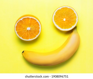 two orange slices and a banana on a yellow background. the figure looks like a smiley. joke concept of vacation and good mood and summer. flat lay. copy space. - Powered by Shutterstock