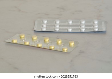 Two Packages Of Pills In Close-up On A White Table. Vitamins, Supplements, Antibiotics, Medications, Emergency Care.