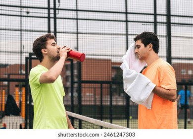 two paddle tennis players resting after a game - Powered by Shutterstock