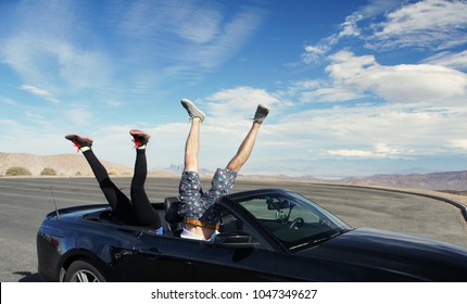 Two pair of legs upside down in a cabriolet car with copy space for the text / Death Valley / USA 