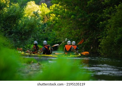 Two pairs of kayakers are kayaking together while having a great time