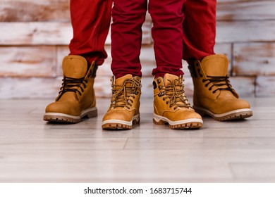 two pairs of legs. men's and children 's feet in brown shoes