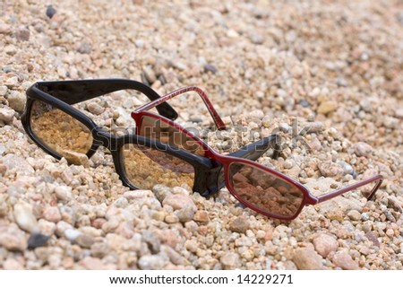 two pairs of sunglasses on the beach