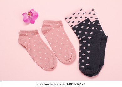 Two Pairs Of Women Socks And Orchid Flower On A Pink Background, Top View.