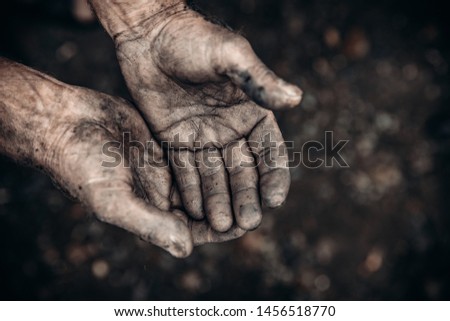 Two palms in mud and calluses are pointing up, hands of refugee and homeless. Concept hard work.