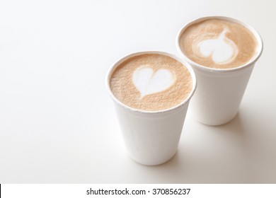 Two Paper Cups Of Coffee With Heart Shape Latte Art
