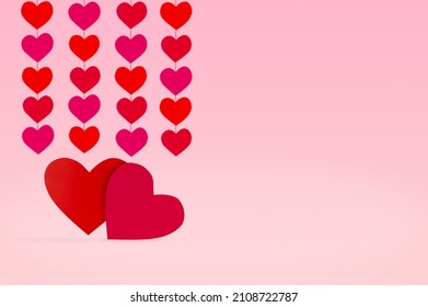 Two Paper Hearts On A Pink Background With Heart Garlands