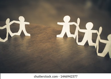 Two paper human chains disconnect or loosing doll in a role of team, teamwork or connection concept