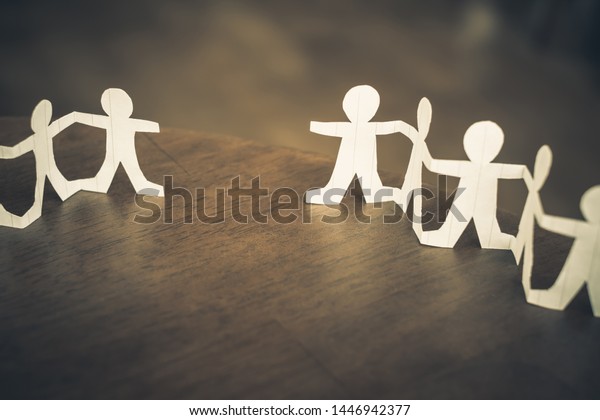 Two paper human chains\
disconnect or loosing doll in a role of team, teamwork or\
connection concept
