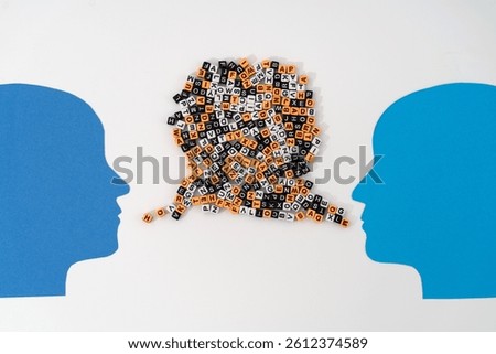 Two paper-cut heads facing each other, with streams of mixed letters flowing from their mouths—symbolizing complex communication, shared thoughts, and the exchange of ideas or emotions or quarrel